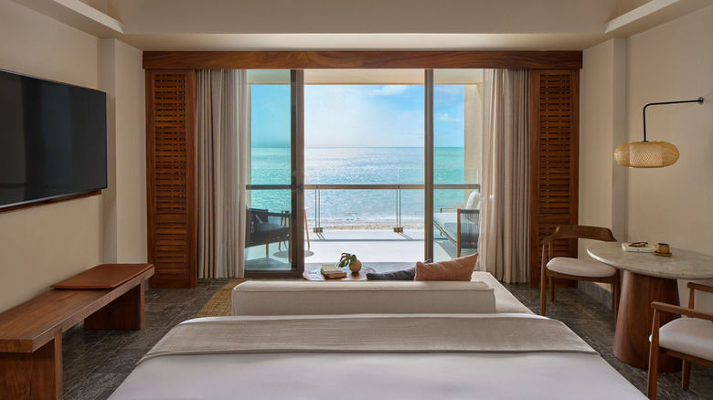 Una habitación de hotel decorada en cálidos tonos madera, piedra natural y tierra con vista al mar en Park Hyatt Riviera Maya