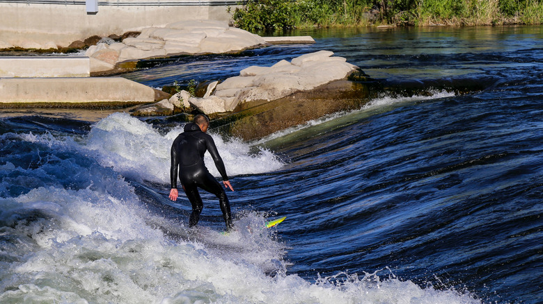 Un hombre surfeando en el río Boise en Boise Whitewater Park a lo largo del cinturón verde del río Boise en Boise, Idaho