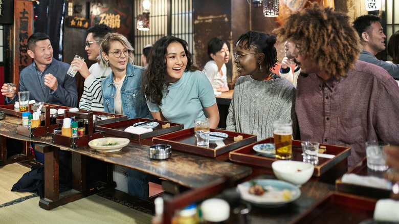 Gente cenando en un tradicional bar de sushi en Tokio, Japón