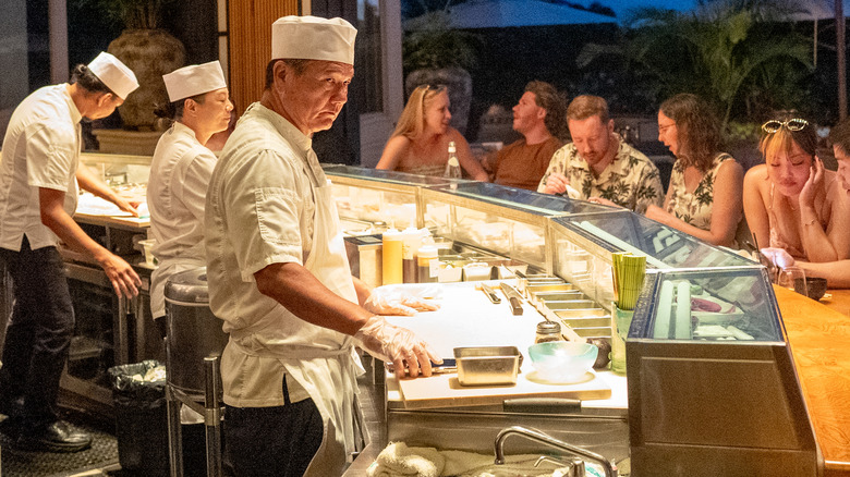Chefs de sushi detrás de la barra de un restaurante de sushi