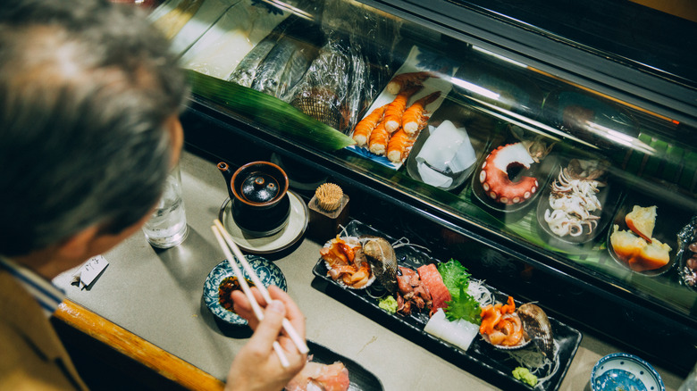 Una comida lujosa y elegante dispuesta frente a un comensal en una barra de sushi