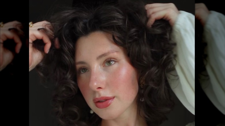 Una persona con maquillaje romántico estilo cottagecore y cabello rizado.