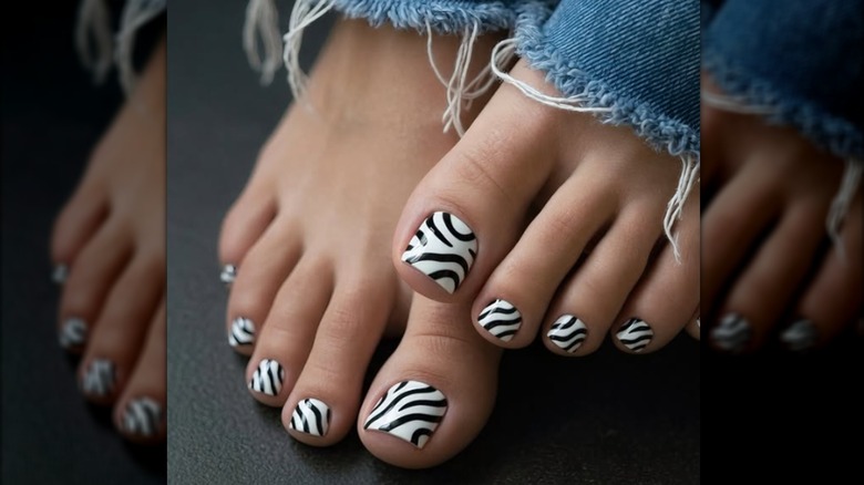 Una pedicura con un diseño de esmalte de uñas con estampado de cebra.