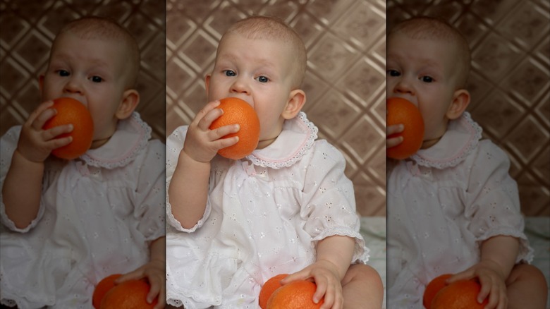 Bebé comiendo una naranja
