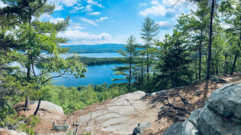 Lago Newfound, New Hampshire, desde un mirador rocoso rodeado de árboles