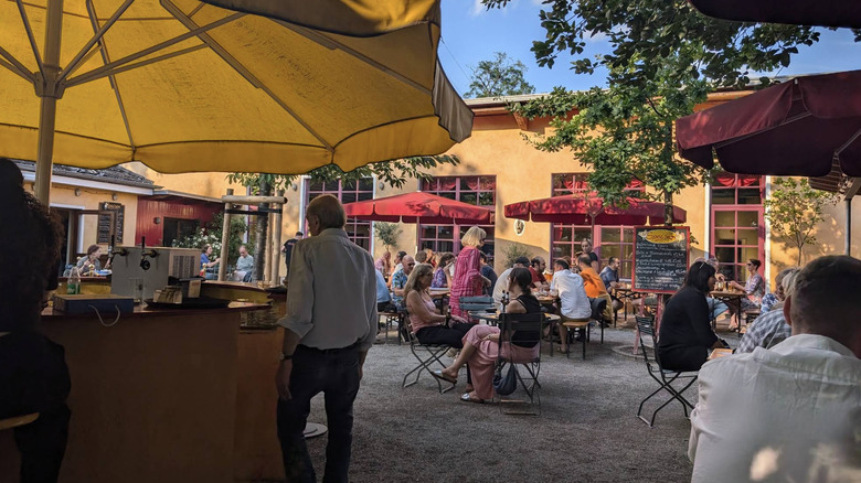 Gente mezclándose en la taberna al aire libre de Alteburg en Colonia