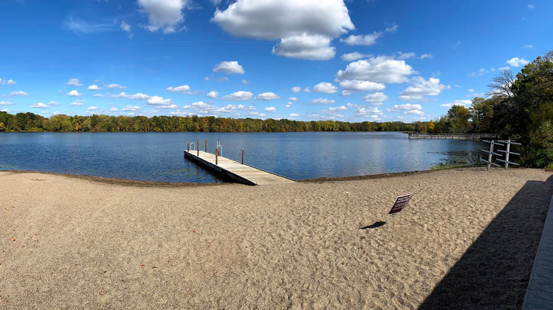 Playa de arena para nadar y muelle en un lago en el Parque Regional Cleary Lake.