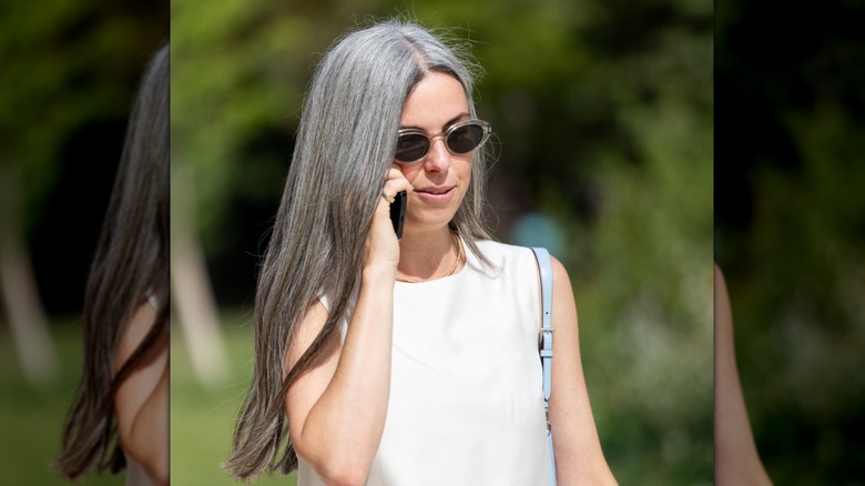 Una mujer con cabello gris y mechas oscuras.