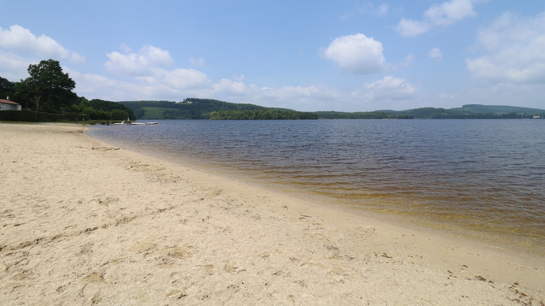 Una amplia y larga playa de arena y aguas cristalinas en el lago de Vassivière