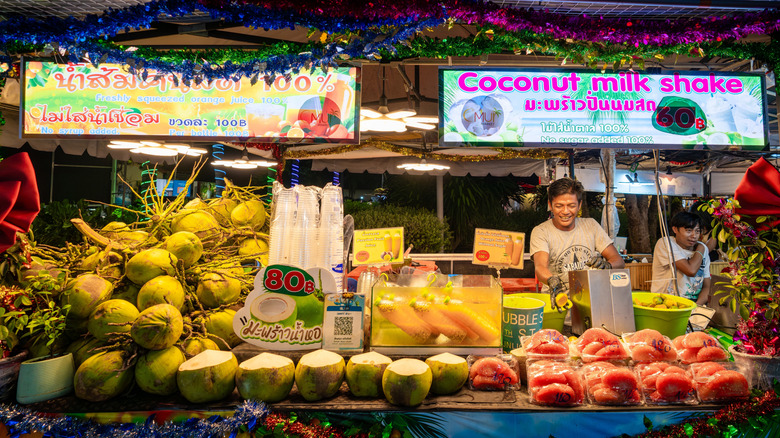 Vendedores de comida vendiendo batidos de frutas en un mercado nocturno en Koh Samui