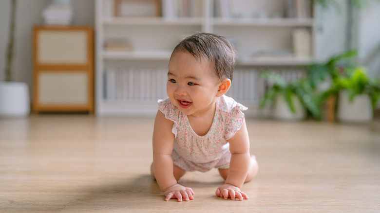 Una niña con un mameluco gateando