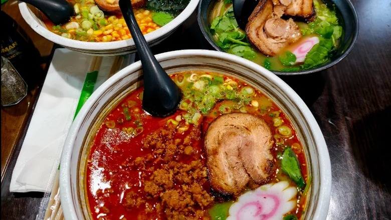 Tres coloridos tazones de ramen sentados en una mesa