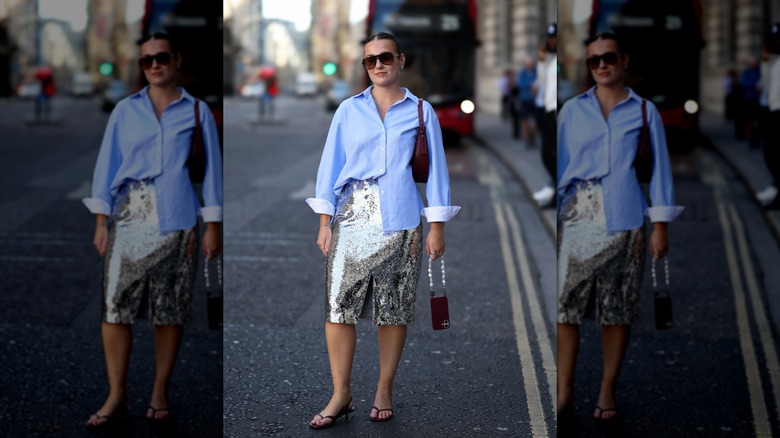 Una mujer vestida con una camisa de algodón azul y una falda de lentejuelas.