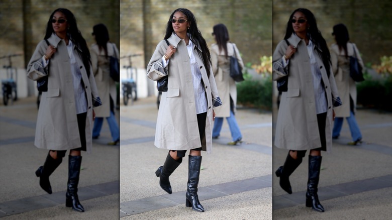 Una mujer vestida con una gabardina beige y botas de cuero negras.