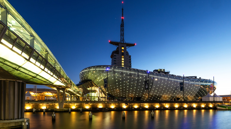 Vista exterior del centro científico Klimahaus, iluminado por la noche, en el centro de Bremerhaven, Alemania