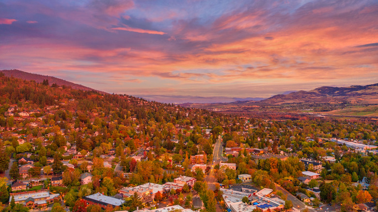Vista aérea de Ashland, Oregón, en otoño al atardecer, con hojas de otoño y un cielo rosa, melocotón y lavanda