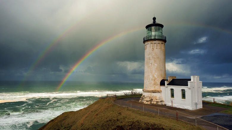 El faro North Head del estado de Washington bajo un doble arco iris