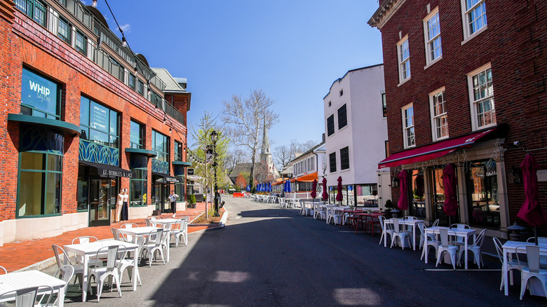Un carril parcialmente sombreado bordeado de restaurantes y edificios en un día claro en Westport, Connecticut