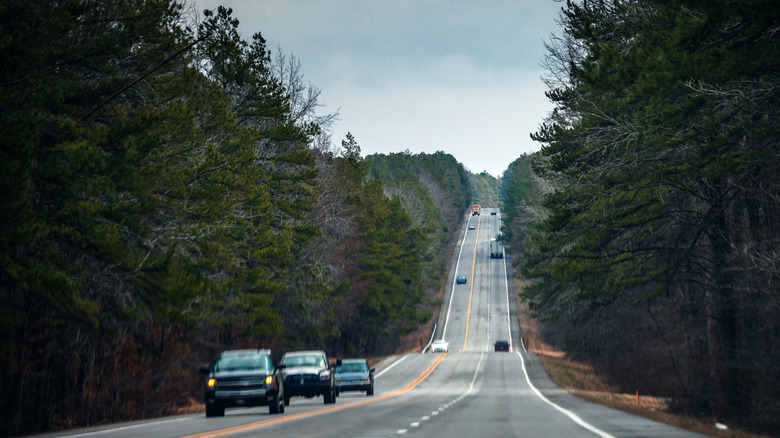 Automóviles circulando por una carretera montañosa rodeada de bosques en Arkansas