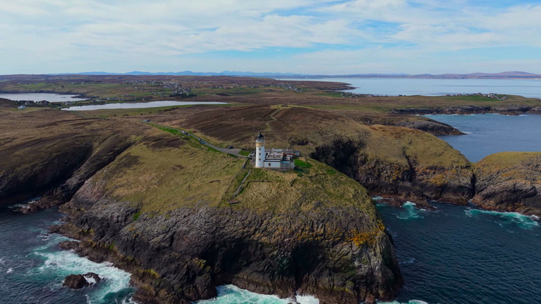 Una vista aérea de gran angular del faro de Dunnet Head al borde de un acantilado