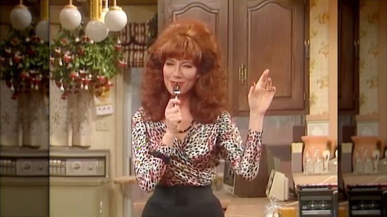 Katey Sagal luciendo una blusa con estampado de leopardo y un voluminoso bouffant pelirrojo