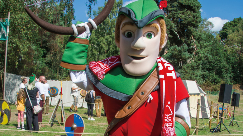 Una mascota de Robin Hood parada frente a familias en una competencia de tiro con arco en Edwinstowe, Inglaterra.