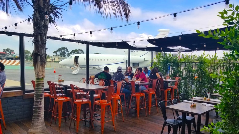 ¡Eureka! Terraza de un restaurante en Hawthorne, California, con una avioneta al fondo.
