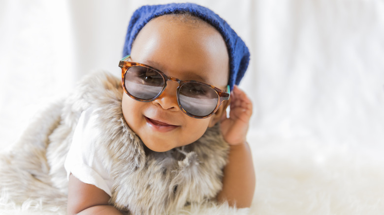 Bebé con gafas de sol y sombrero.