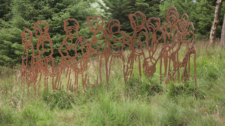 Escultura de color cobre de mujeres que supuestamente eran brujas en la hierba a lo largo del Pendle Sculpture Trail en las afueras de Nelson