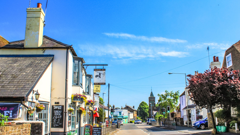 Un pub, una tienda de pescado y patatas fritas y una iglesia en un día soleado en Walmer, Kent