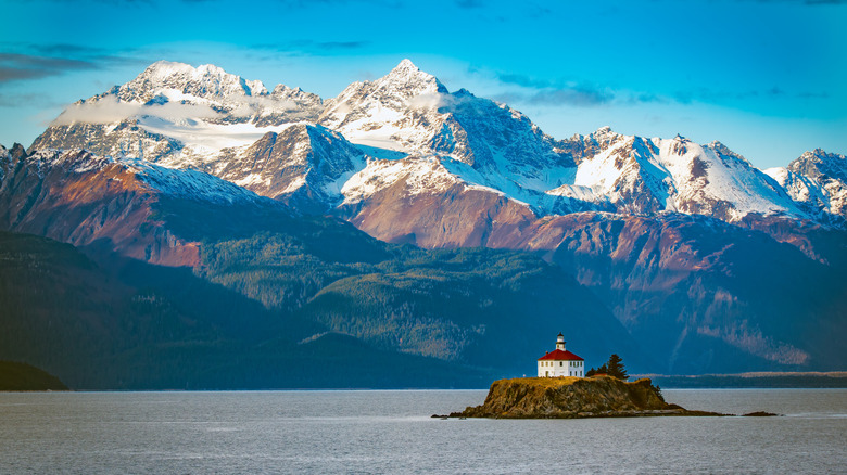 El faro de Eldred Rock en Alaska con vistas a las montañas al fondo.