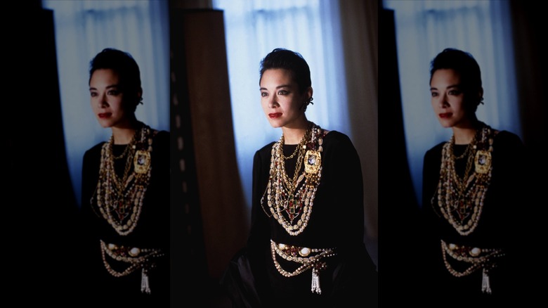 Una mujer morena que llevaba una pila de collares de cadena de oro