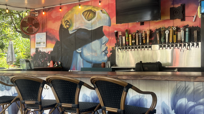 Colorido mural detrás de la barra con varios grifos de cerveza en The Lagoon on Grassy Key en Marathon, Florida
