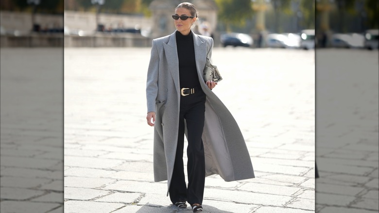 Una mujer que llevaba un bolso estructural y gafas de sol.