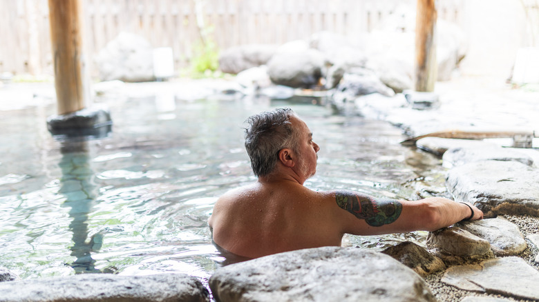 Un extranjero en unas aguas termales de Japón con un tatuaje.