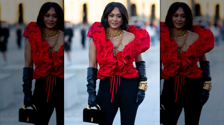 Una mujer con guantes de ópera negros y joyas de oro.