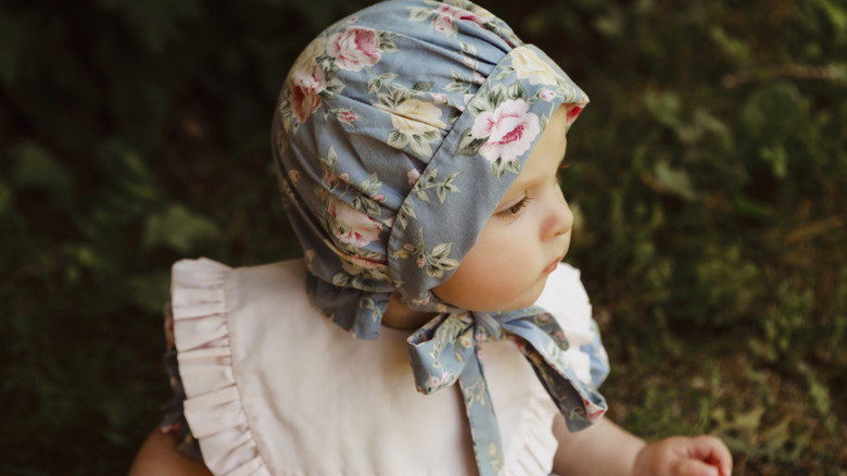 Una niña con gorro y babero.
