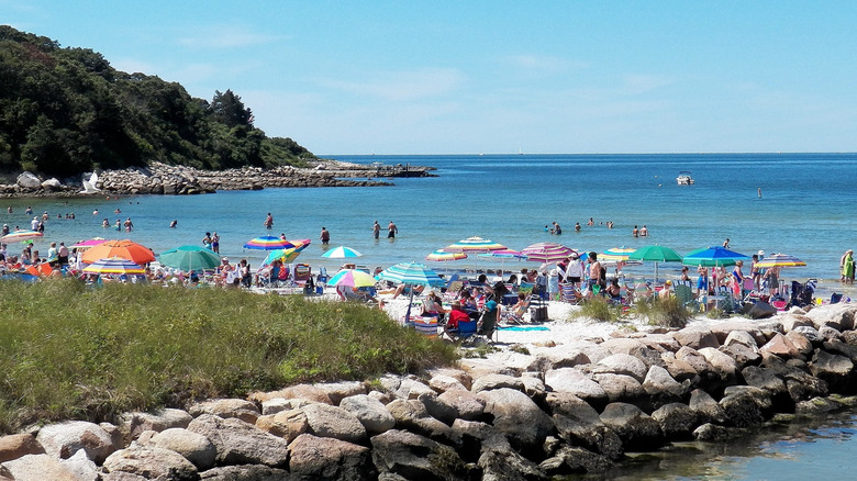 Ajetreado día de playa en Old Silver Beach en Falmouth, Massachusetts en Cape Cod, coloridas sombrillas sobre multitudes