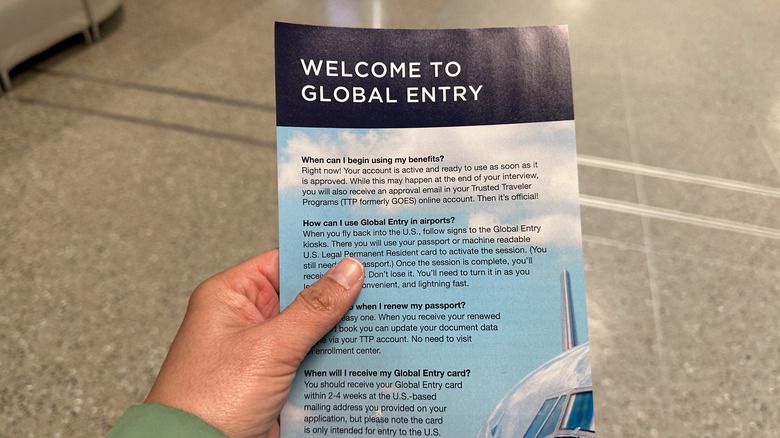 Mano sosteniendo el folleto de bienvenida a Global Entry