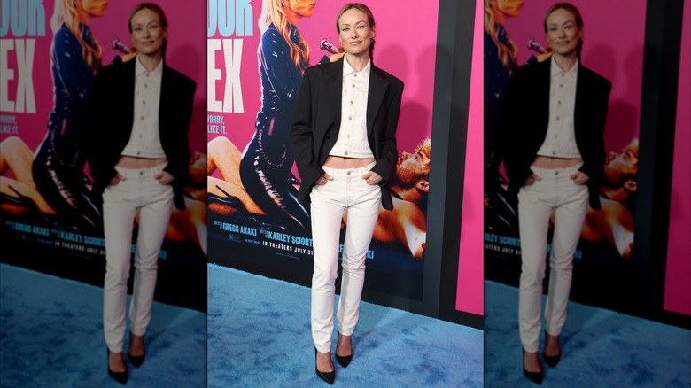 Olivia Wilde con jeans ajustados blancos y una chaqueta negra en el 