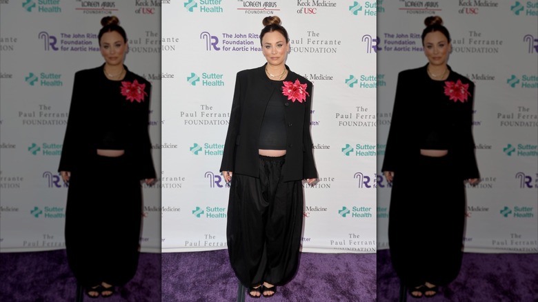 Kaley Cuoco sonríe con traje negro