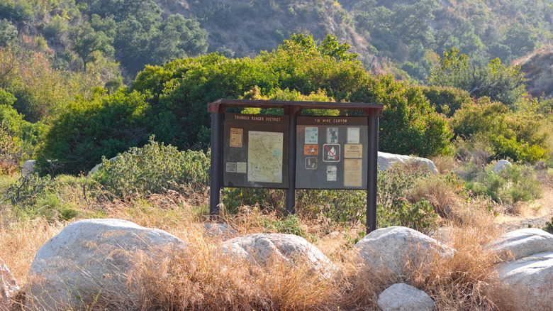 Esta es una imagen de señalización informativa para Tin Mine Trail en Corona, California.