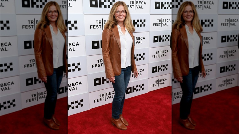 Elizabeth Shue luciendo jeans con top blanco y chaqueta marrón con zapatos a juego en la Good Half Premierre