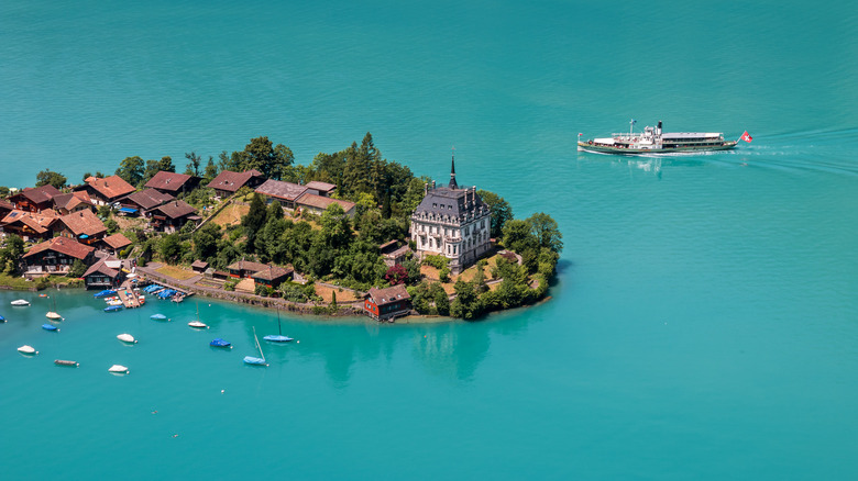 Una vista aérea de Iseltwald, rodeada por el lago Brienz, con un crucero a vapor al fondo