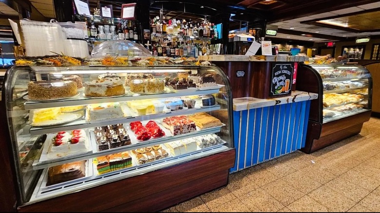 Interior de State Line Diner en Mahwah, Nueva Jersey, con una caja de pastel con acabados de madera frente a una barra