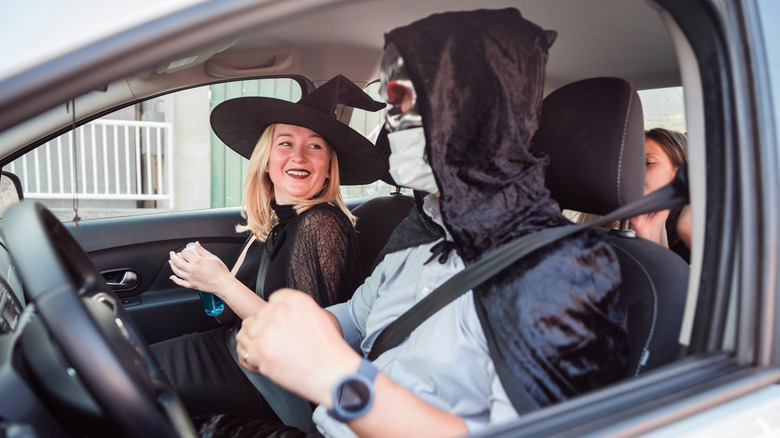 Una familia en un coche, disfrazada de Halloween.