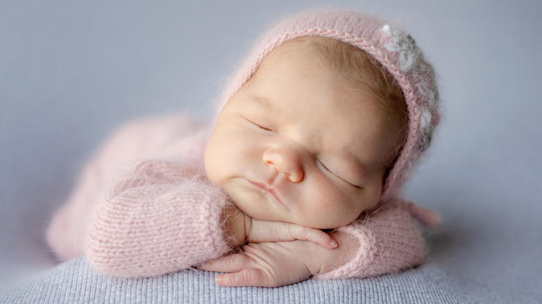 Una niña recién nacida sonriendo mientras duerme