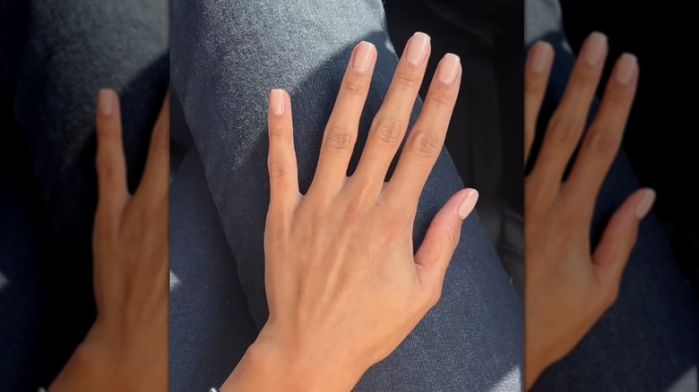 Mujer con uñas rosa pálido.