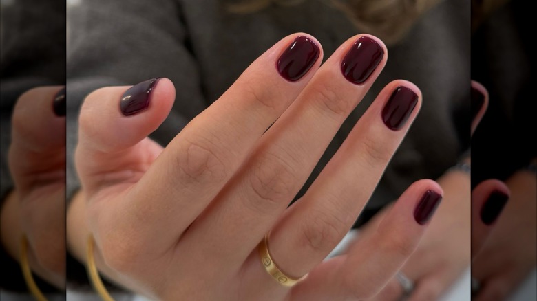 Mujer con uñas color burdeos