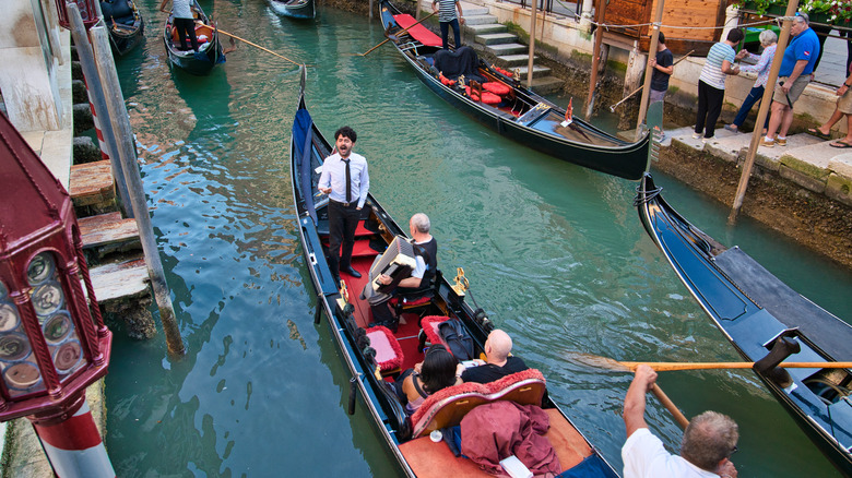 Un hombre canta en una góndola mientras otro toca el acordeón en el canal de Venecia